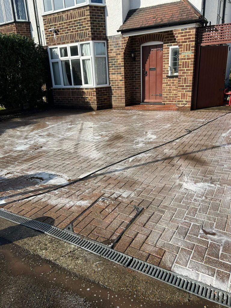 applying cleaning chemical to driveway